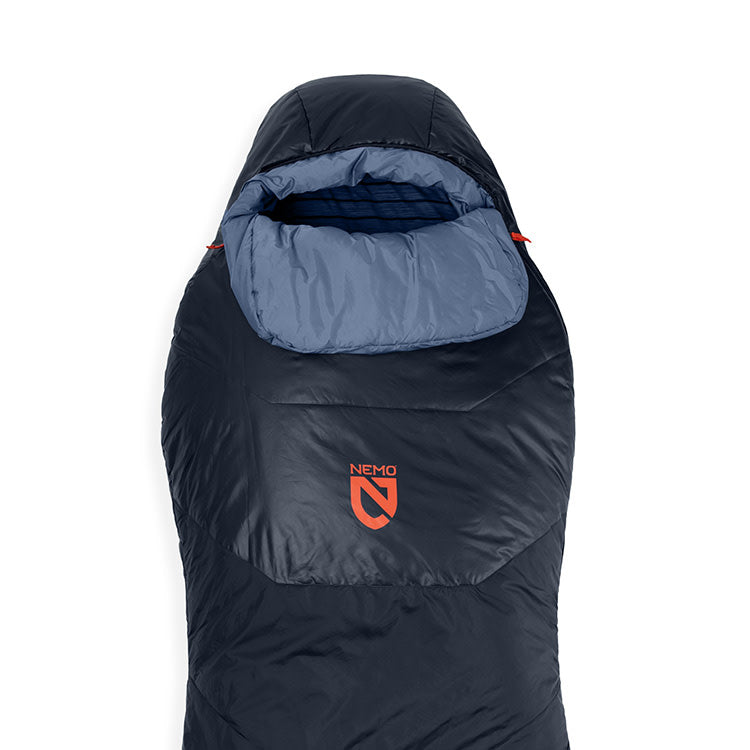 The NEMO Equipment Tempo™ Men's Endless Promise Synthetic Sleeping Bag is dark blue with a lighter blue hood and showcases the orange NEMO logo on the front, ideal for side sleepers.